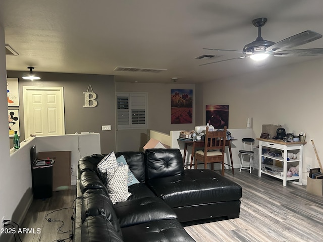 living room with wood-type flooring and ceiling fan