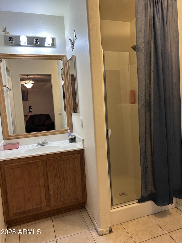 bathroom featuring ceiling fan, tile patterned floors, a shower with shower door, and sink