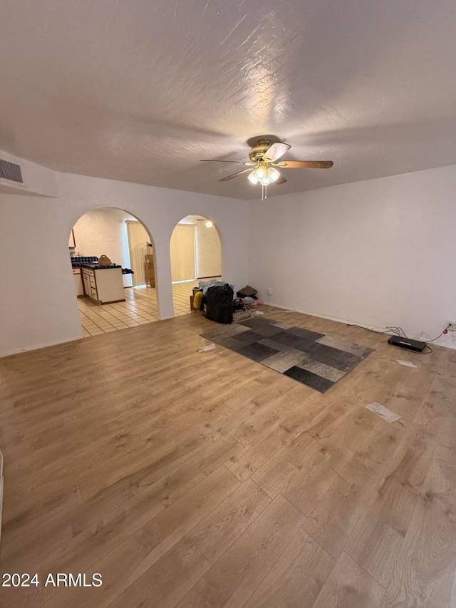 exercise room with light hardwood / wood-style floors and ceiling fan