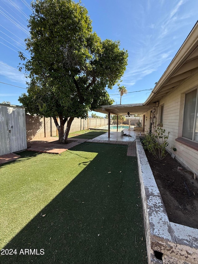 view of yard featuring a storage unit and a patio area