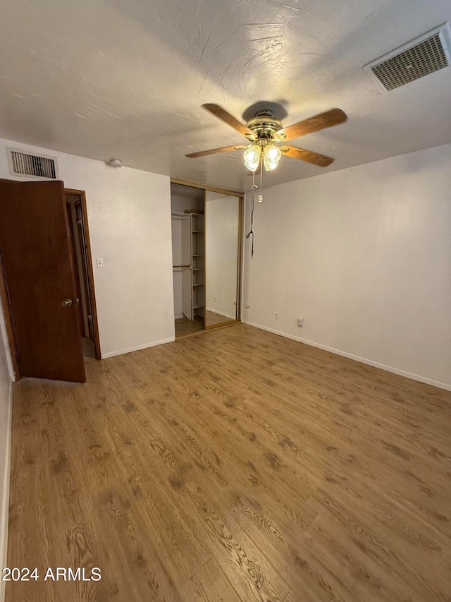 interior space featuring a closet, a textured ceiling, hardwood / wood-style flooring, and ceiling fan