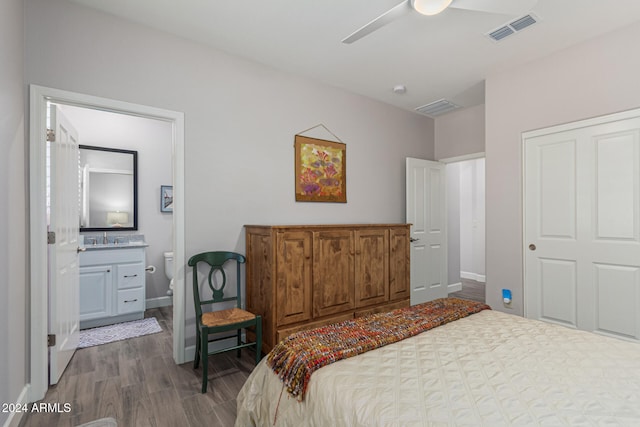 bedroom featuring ensuite bath, ceiling fan, and dark wood-type flooring