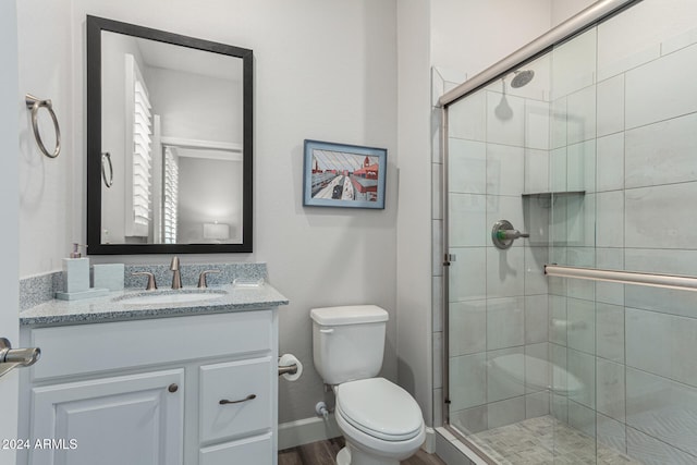 bathroom featuring an enclosed shower, vanity, toilet, and wood-type flooring