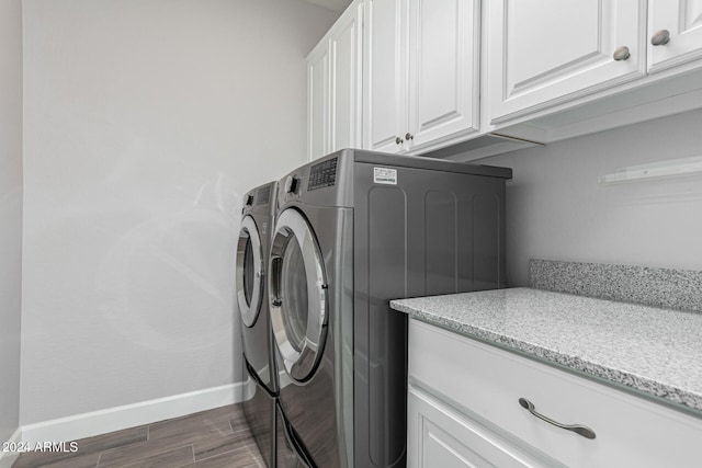 laundry room featuring cabinets, independent washer and dryer, and dark wood-type flooring