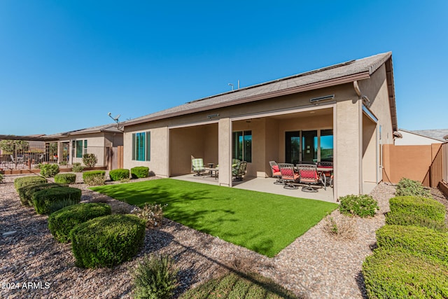 back of property with a patio area and a lawn