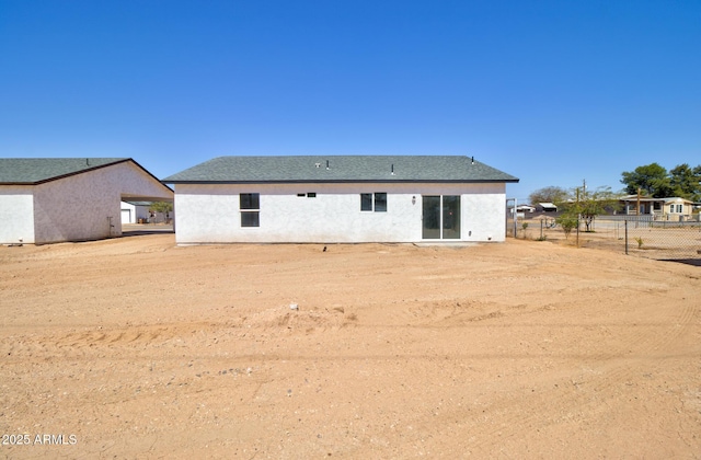 back of house with fence and stucco siding