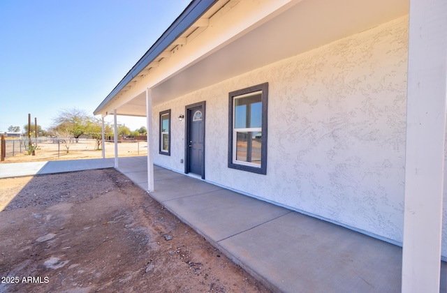 exterior space featuring fence and stucco siding