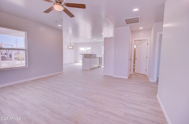 unfurnished living room featuring light wood-type flooring, visible vents, baseboards, and recessed lighting