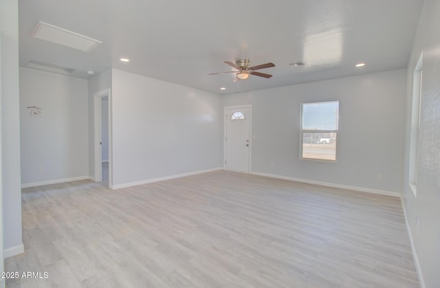 empty room with ceiling fan, light wood-style floors, visible vents, and baseboards