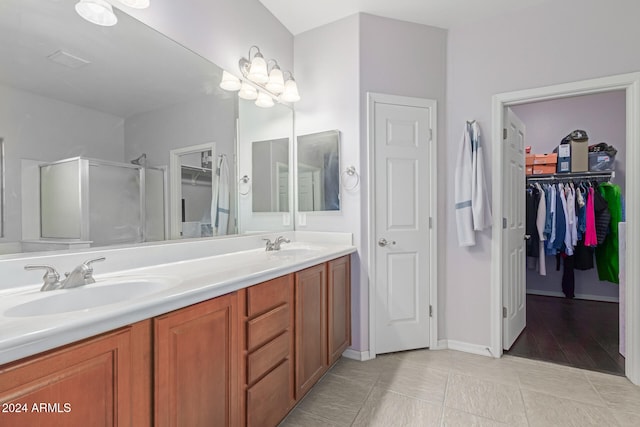 bathroom featuring tile patterned flooring, vanity, and a shower with door