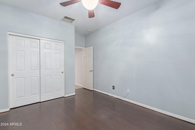 unfurnished bedroom featuring ceiling fan, dark hardwood / wood-style floors, and a closet