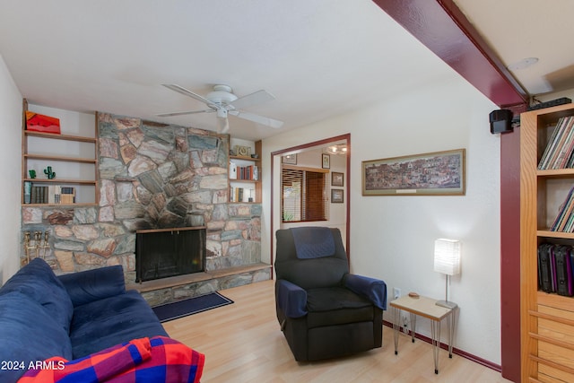 living room featuring ceiling fan, a fireplace, and light hardwood / wood-style flooring