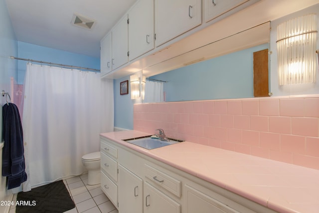 bathroom featuring tile patterned flooring, vanity, decorative backsplash, and toilet