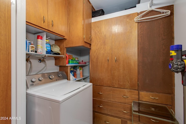 clothes washing area with washer / dryer and cabinets