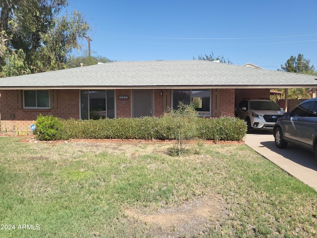 single story home featuring a front lawn and a carport