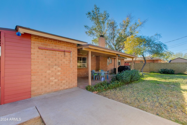 exterior space with a patio and a lawn