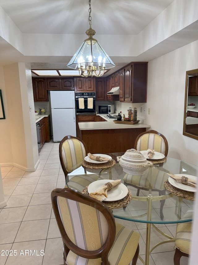 dining room with a chandelier, light tile patterned floors, and baseboards