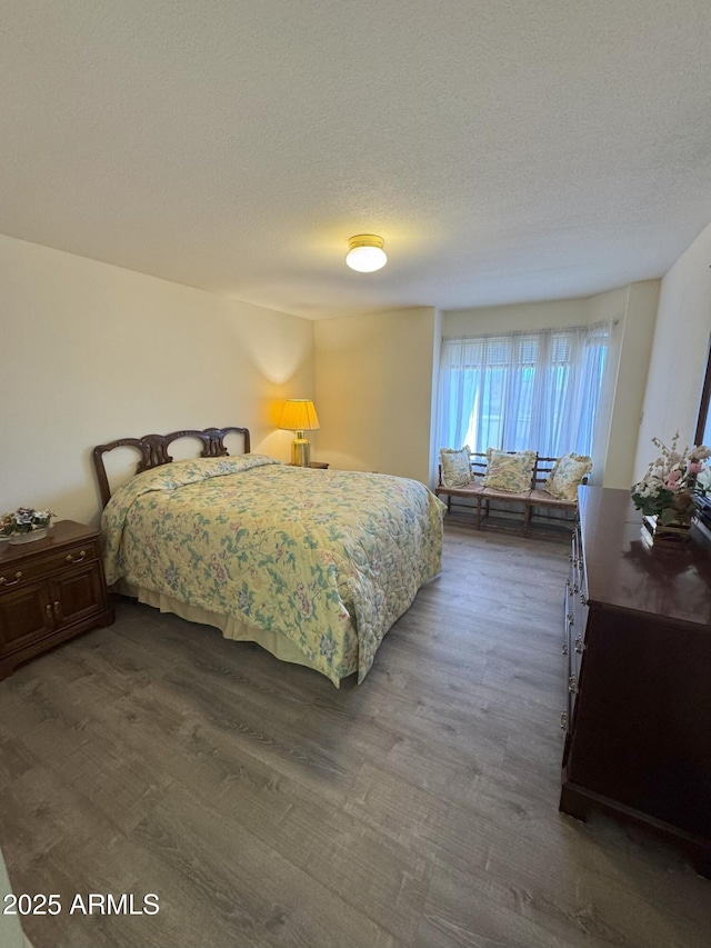 bedroom featuring a textured ceiling and dark wood-type flooring