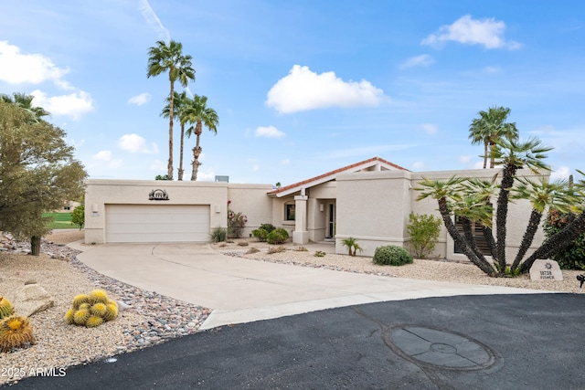 view of front of house featuring concrete driveway, a garage, and stucco siding