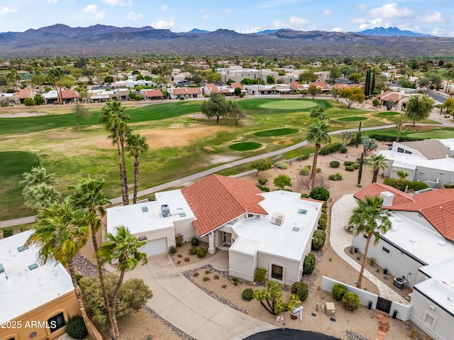 drone / aerial view with view of golf course, a mountain view, and a residential view