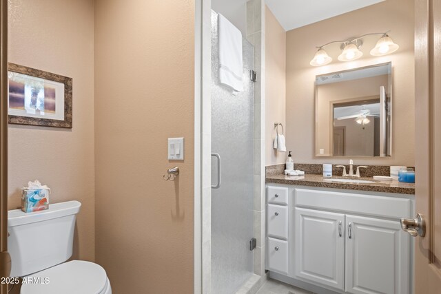 bathroom featuring vanity, a shower stall, toilet, and a ceiling fan