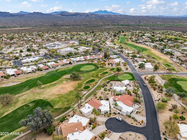 drone / aerial view with a mountain view, golf course view, and a residential view