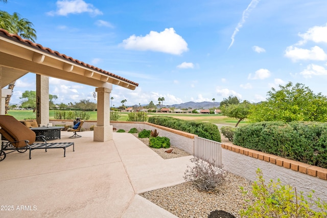 view of patio / terrace with a mountain view and fence