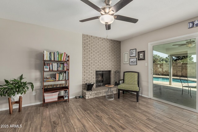 3741 W Poinsettia Dr, Phoenix, AZ 85029 - living area with ceiling fan, wood finished floors, a brick fireplace, and baseboards