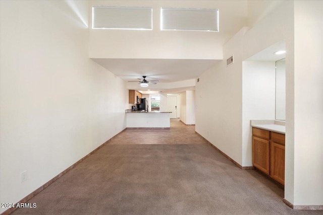 unfurnished living room featuring ceiling fan and light colored carpet