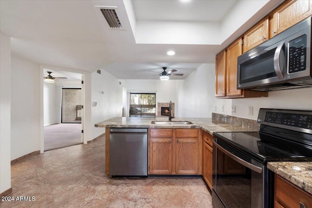 kitchen featuring kitchen peninsula, appliances with stainless steel finishes, ceiling fan, and sink