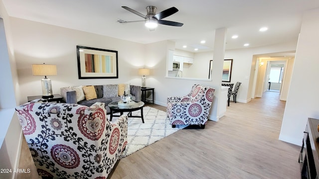 living room featuring ceiling fan and light wood-type flooring