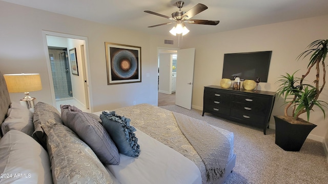 carpeted bedroom with ensuite bathroom and ceiling fan