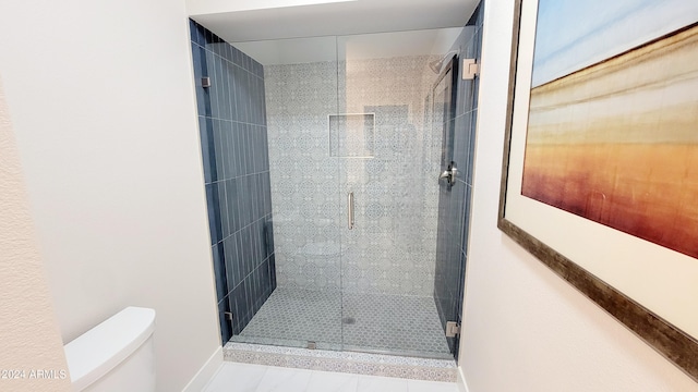 bathroom featuring tile patterned floors, toilet, and walk in shower