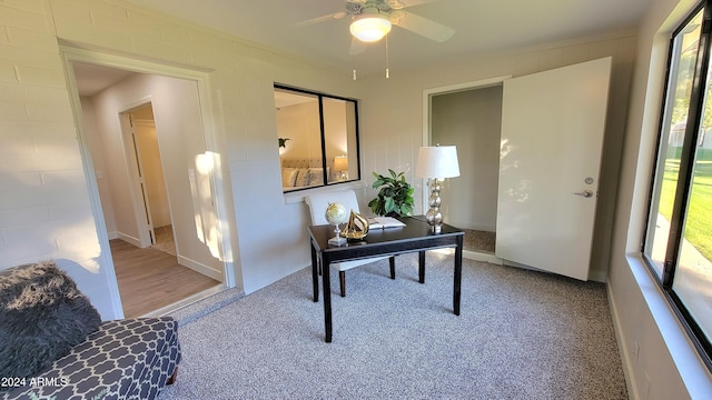 home office featuring light carpet and ceiling fan