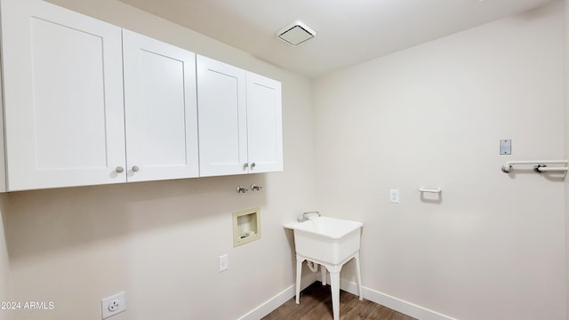 washroom with cabinets, washer hookup, and dark hardwood / wood-style flooring