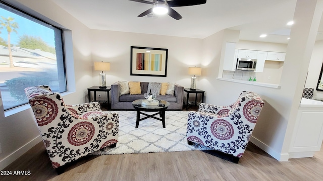 living room with light hardwood / wood-style floors and ceiling fan