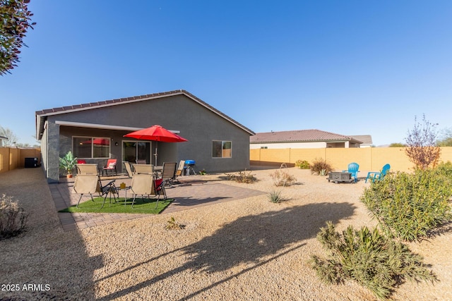 rear view of property featuring a patio area and an outdoor fire pit