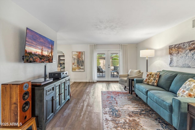 living room featuring visible vents, baseboards, wood finished floors, and french doors