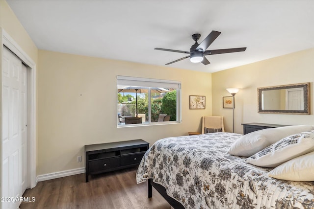 bedroom featuring a closet, wood finished floors, a ceiling fan, and baseboards