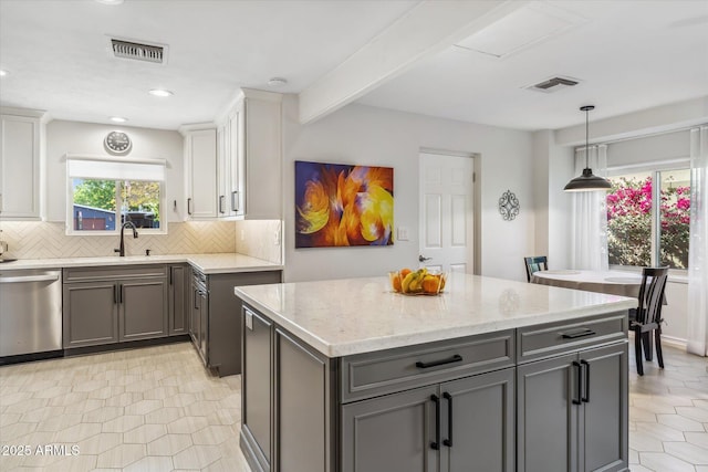 kitchen with tasteful backsplash, visible vents, gray cabinets, and dishwasher