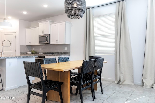 kitchen with appliances with stainless steel finishes, backsplash, a sink, and a wealth of natural light