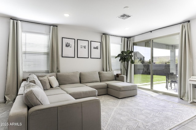 living area featuring light tile patterned flooring, visible vents, and recessed lighting