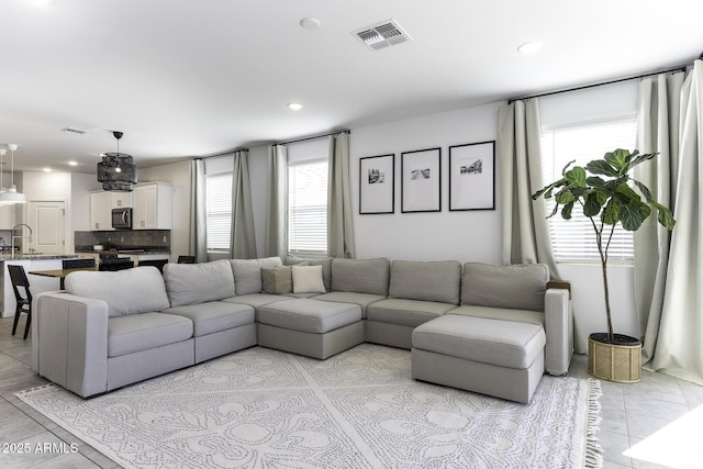 living room with light tile patterned floors, visible vents, and recessed lighting