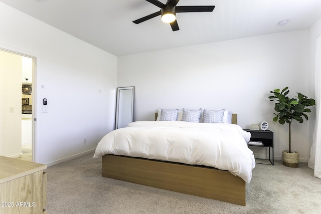 bedroom featuring light colored carpet, ceiling fan, and baseboards