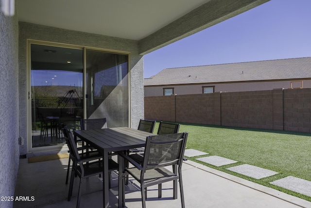 view of patio with outdoor dining area and fence