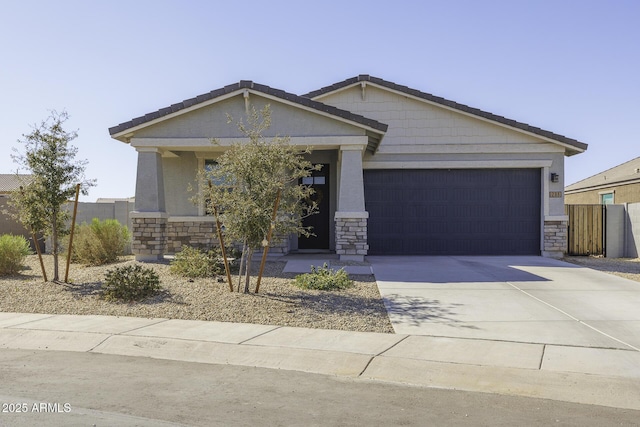 view of front facade featuring driveway, stone siding, an attached garage, and fence