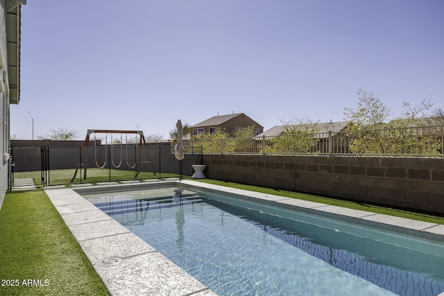 view of pool with a playground and a fenced backyard