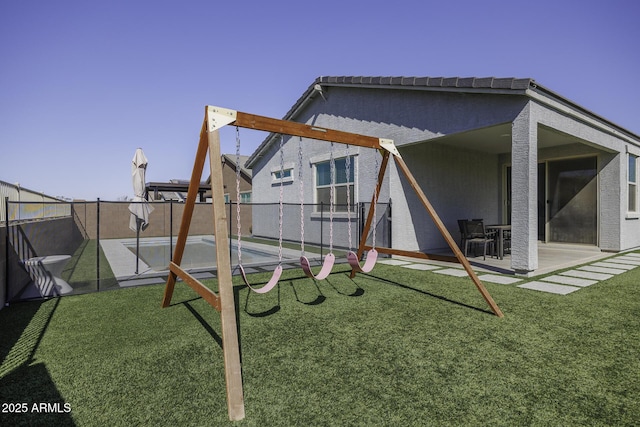 view of play area with a yard, a fenced backyard, and a patio