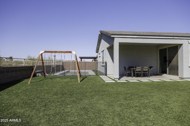 view of yard with a patio area, a fenced backyard, and a playground