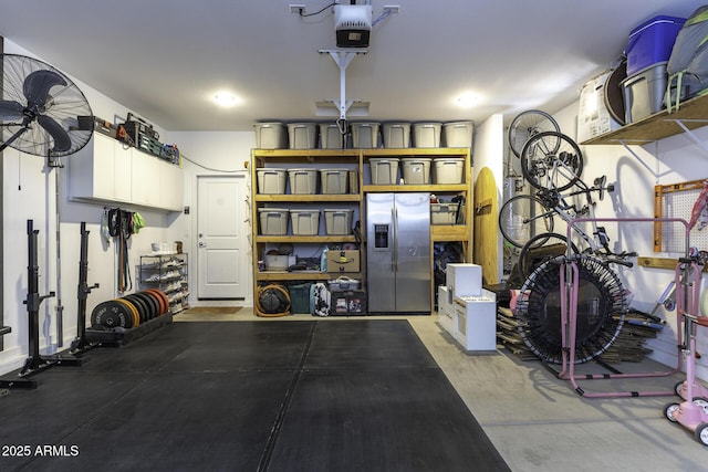 garage with a garage door opener and stainless steel fridge